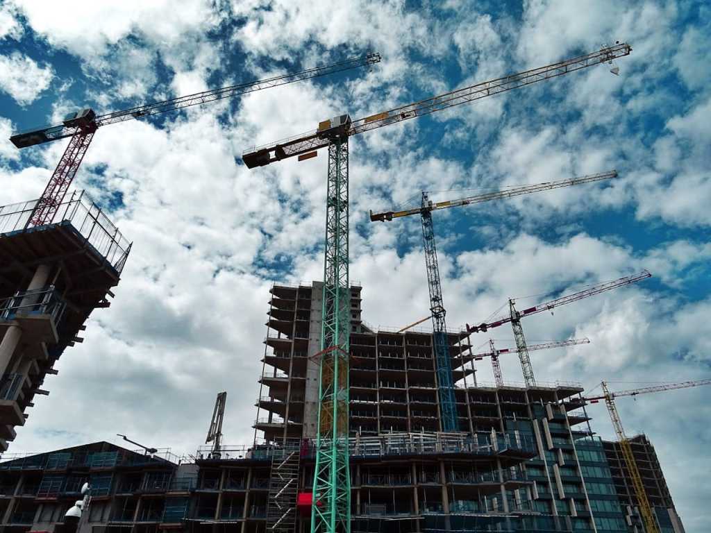 Several construction cranes working on buildings.