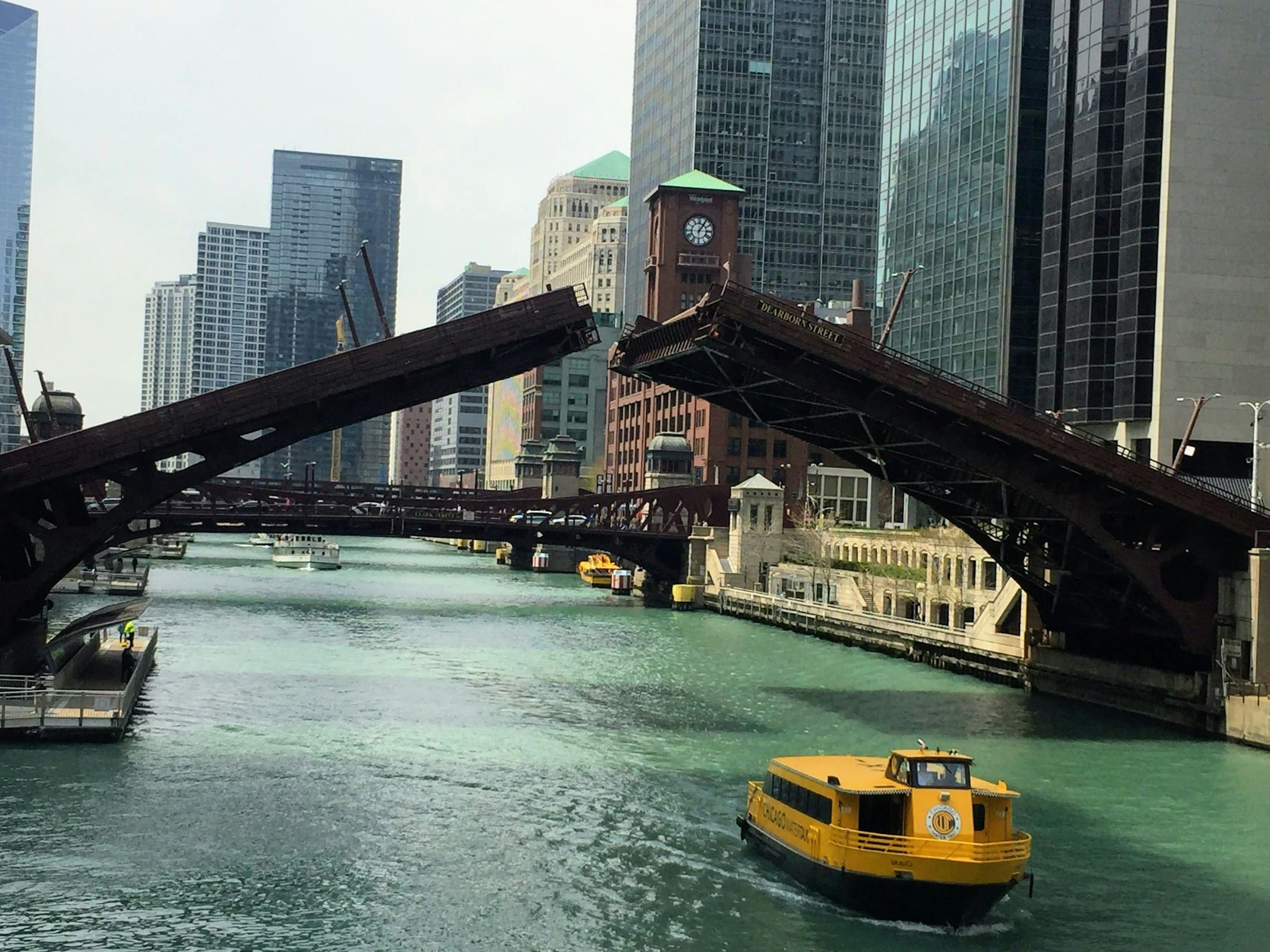 A boat going under raised bridges on the Chicago River.