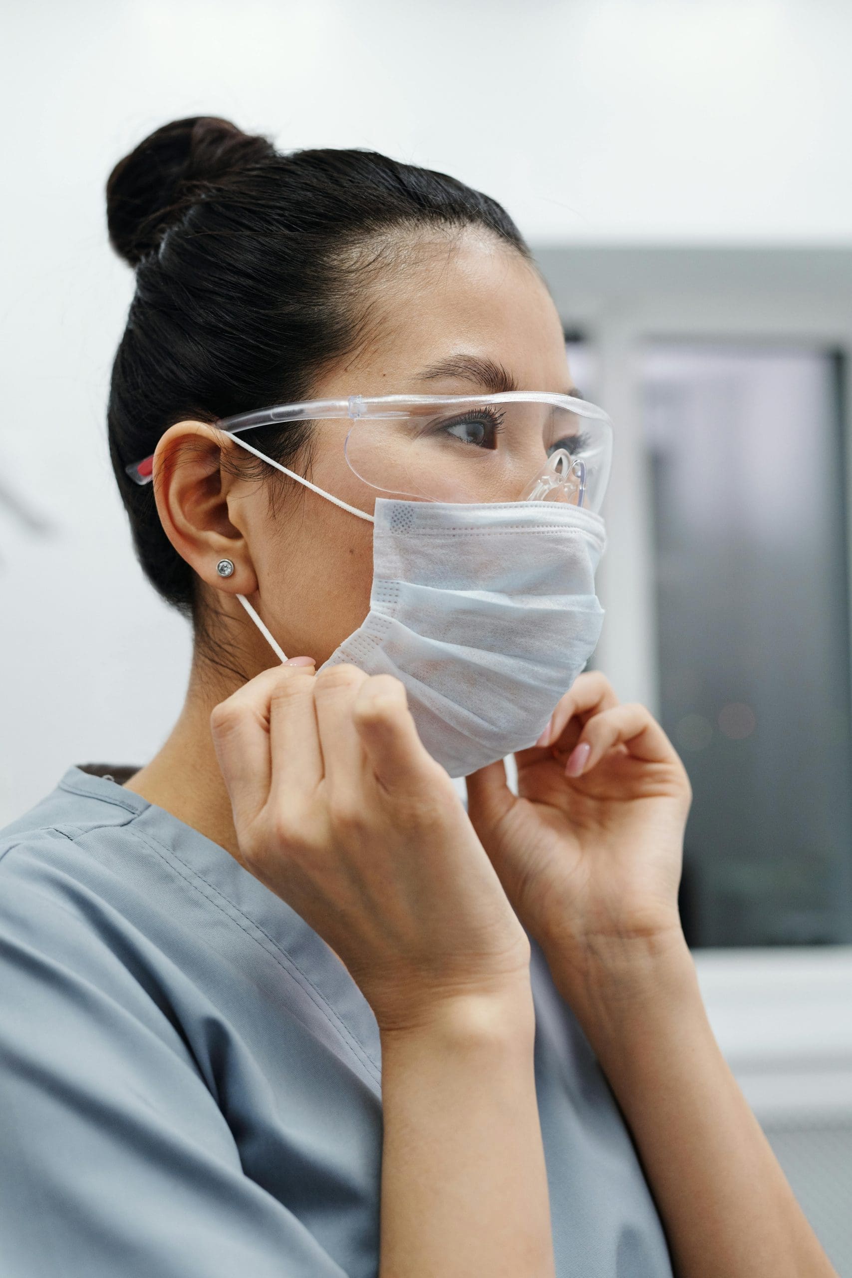 A medical professional putting on a mask.