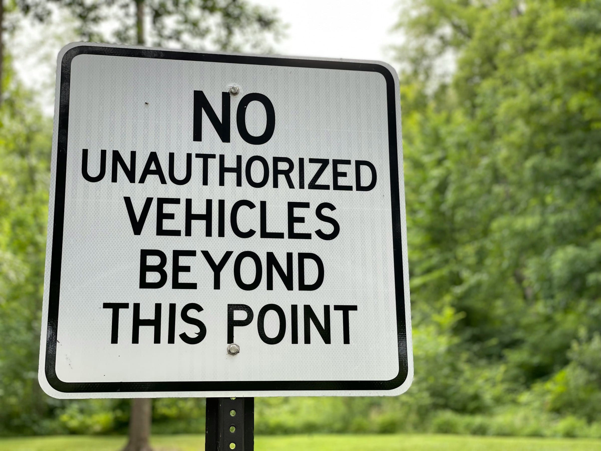 A sign letting people know that no cars are allowed past a designated point.