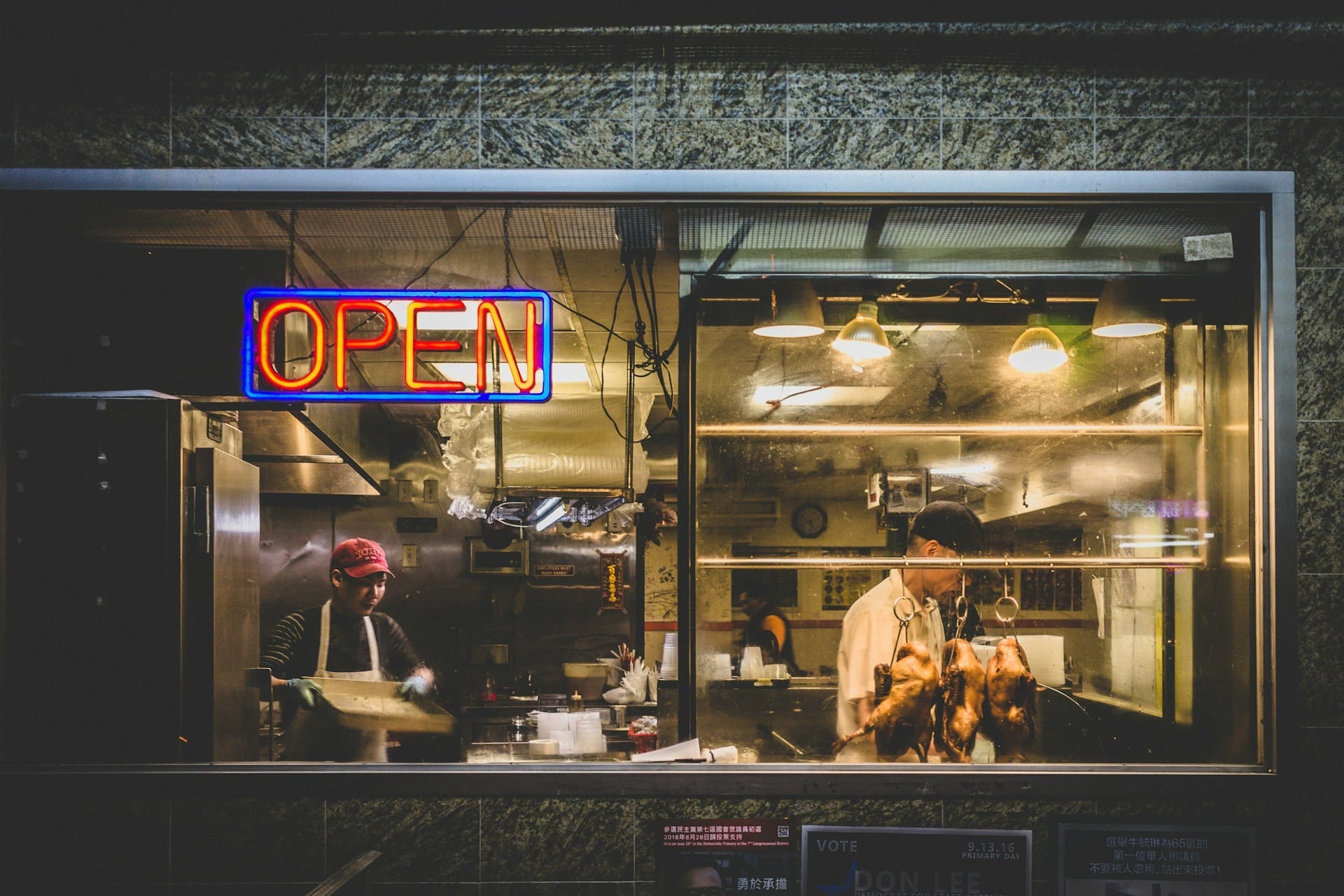 Two people working in a restaurant at night.